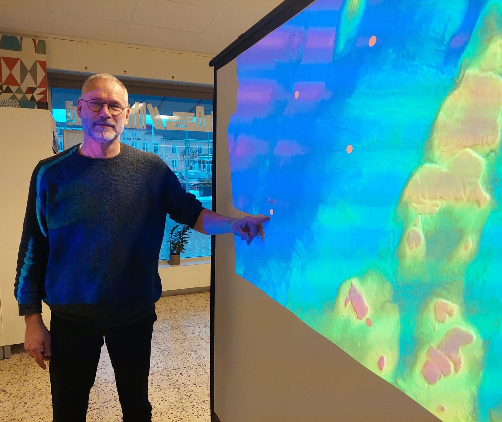 Man pekar på en geologisk karta.